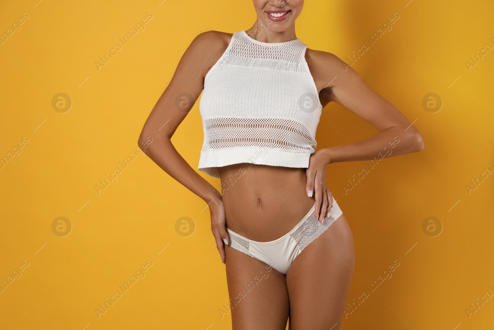 Photo of Woman in white sexy panties on yellow background, closeup