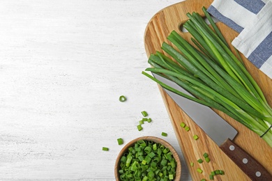 Photo of Flat lay composition with fresh green onions on white wooden background. Space for text