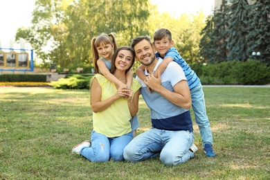 Photo of Happy family with children spending time together in green park on sunny day