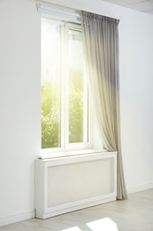 Image of Bright sun shining through window with stylish curtain