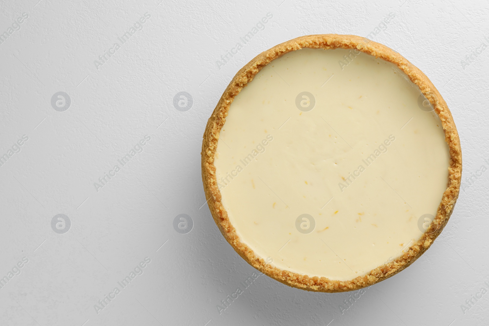 Photo of Tasty vegan tofu cheesecake on white table, top view. Space for text