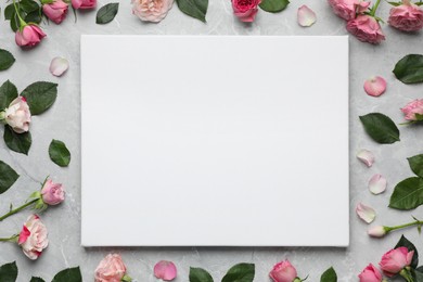 Photo of Flat lay composition with blank canvas and beautiful roses on grey marble background. Mockup for design