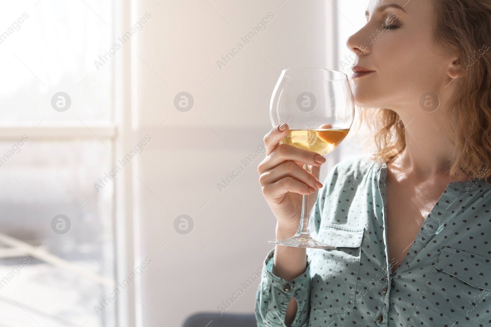 Photo of Woman with glass of delicious wine indoors