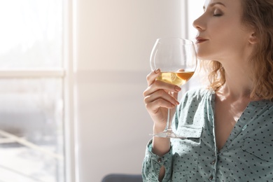 Photo of Woman with glass of delicious wine indoors