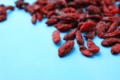 Dried goji berries on light blue background, closeup