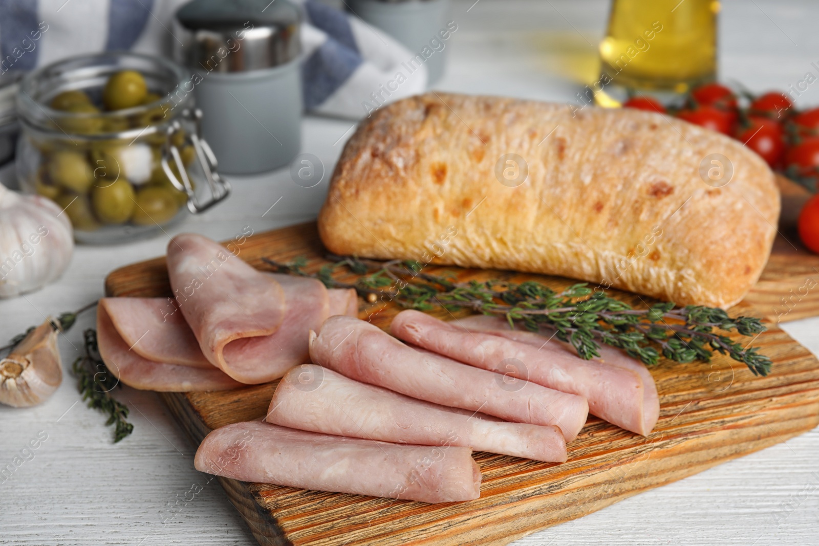 Photo of Slices of tasty ham on white wooden table