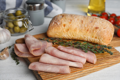 Slices of tasty ham on white wooden table