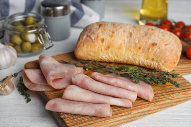 Photo of Slices of tasty ham on white wooden table