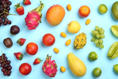 Photo of Many different delicious exotic fruits on light blue background, flat lay