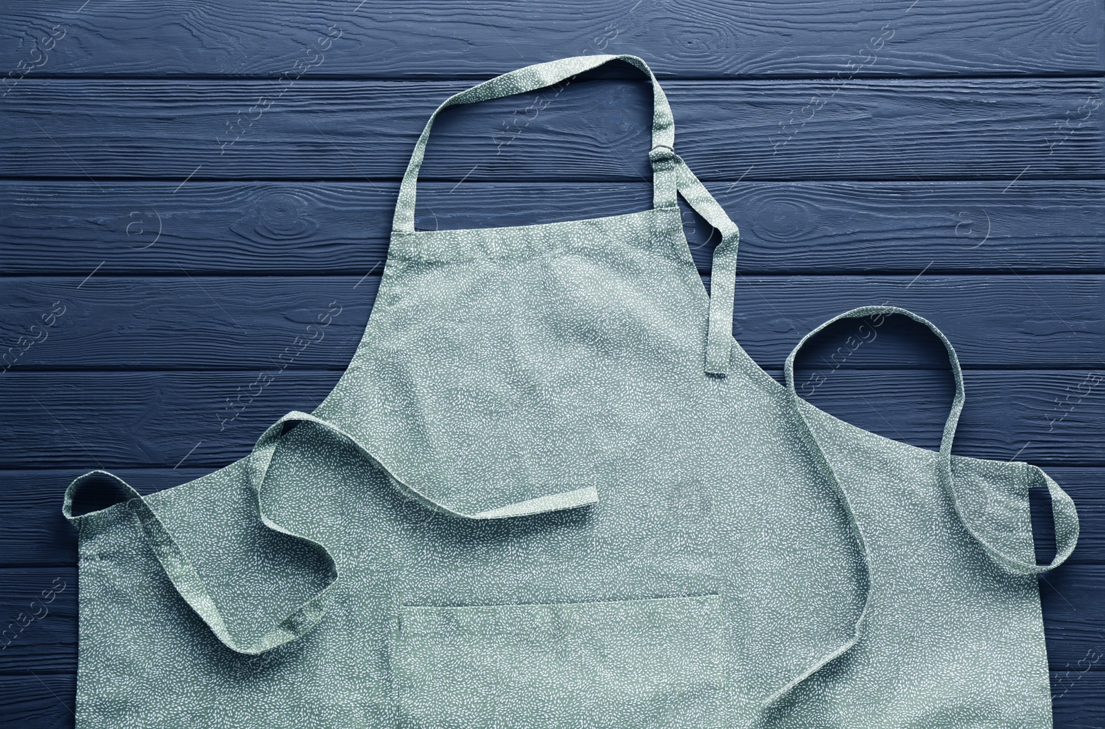 Photo of Color apron with pattern on grey wooden table, top view