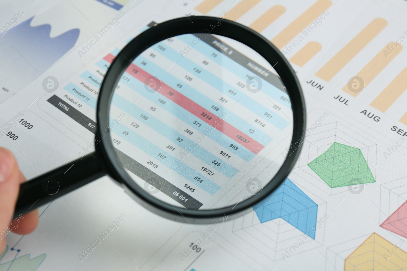 Photo of Accountant looking at document through magnifying glass, closeup