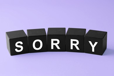 Image of Apology. Word Sorry made of black cubes on violet background