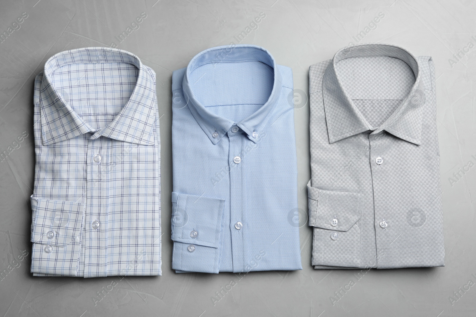 Photo of Stylish male shirts on light grey background, flat lay