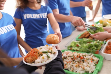 Photo of Volunteers serving food to poor people, closeup