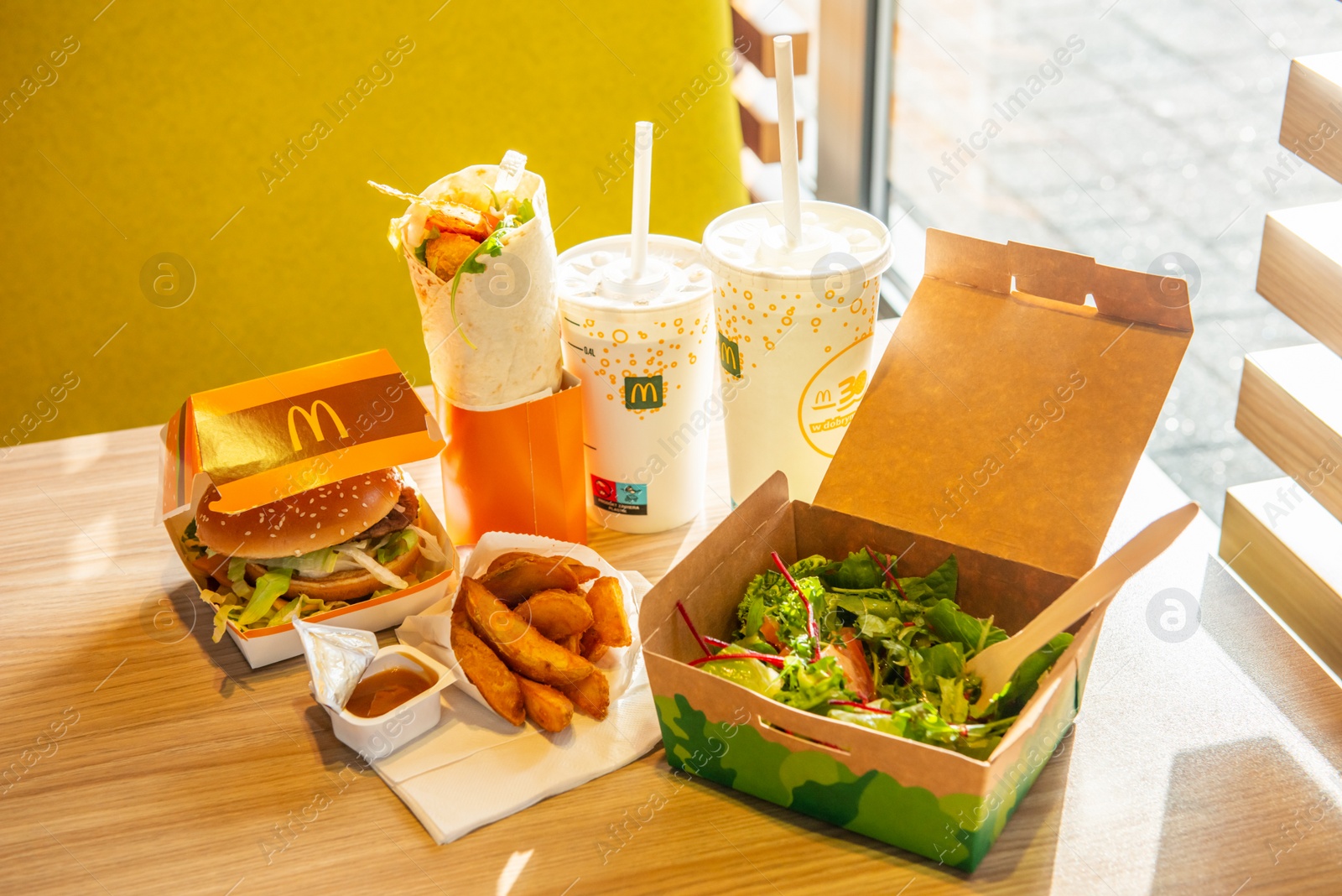 Photo of WARSAW, POLAND - SEPTEMBER 16, 2022: Big Mac hamburger, fried potatoes and cold drinks on table in McDonald's cafe