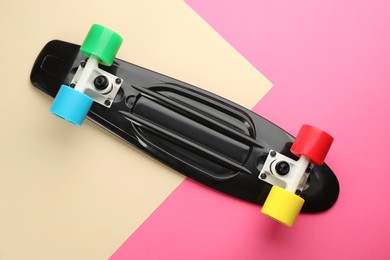 Photo of Black skateboard on color background, top view