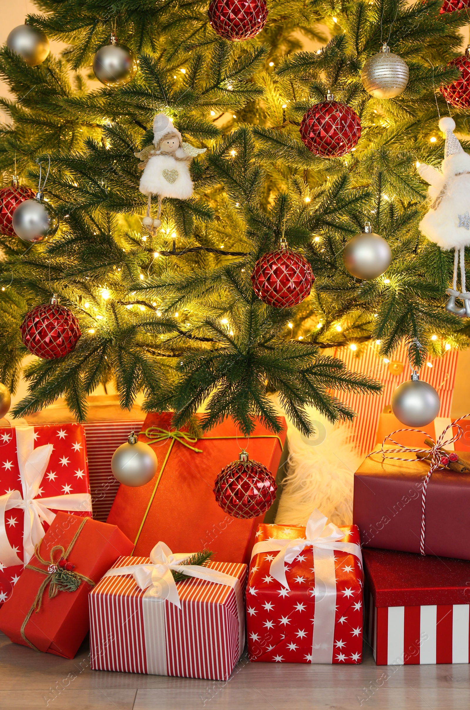 Photo of Pile of gift boxes near Christmas tree indoors