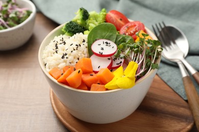 Photo of Bowl with many different vegetables and rice on wooden table. Vegan diet