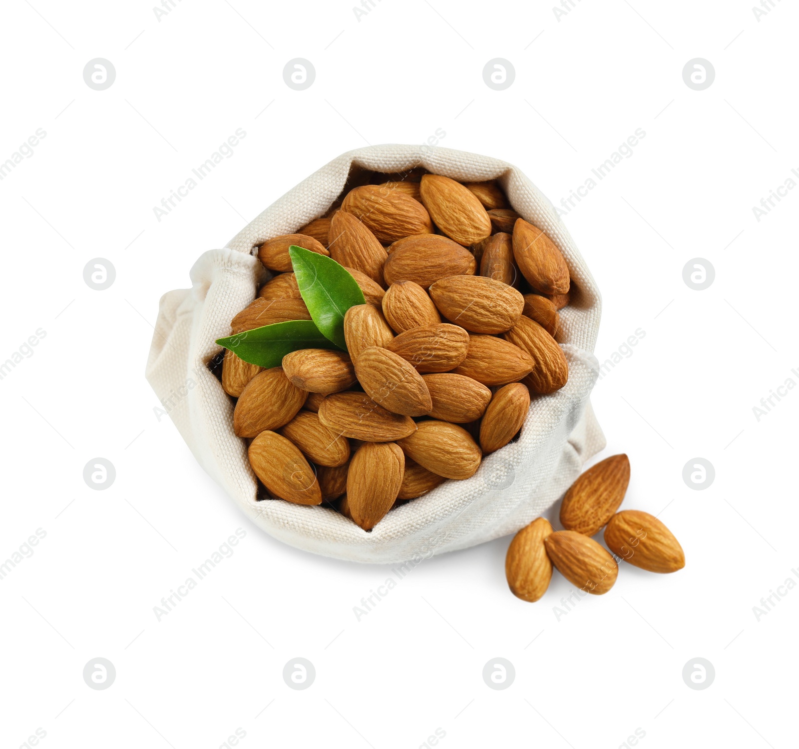 Photo of Sack with organic almond nuts and green leaves on white background, top view. Healthy snack