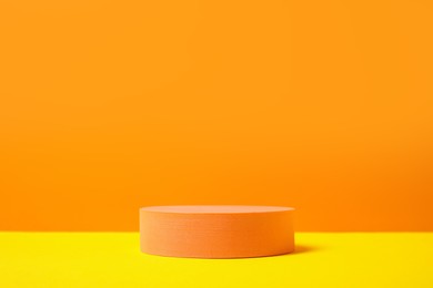 Photo of Round stand on orange background, space for text. Stylish presentation for product