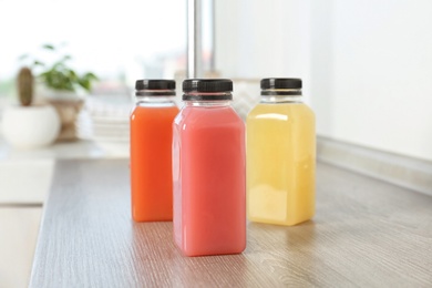 Bottles with fresh tasty juices on table