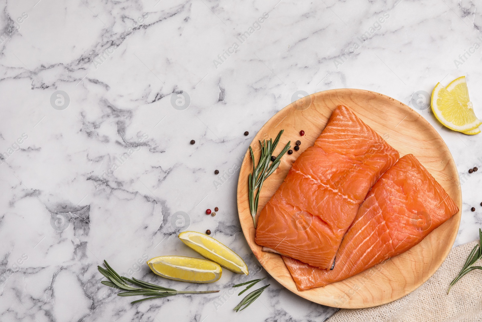 Photo of Wooden plate with tasty salmon fillet on marble table, flat lay. Space for text