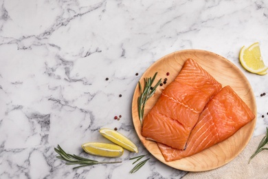 Photo of Wooden plate with tasty salmon fillet on marble table, flat lay. Space for text