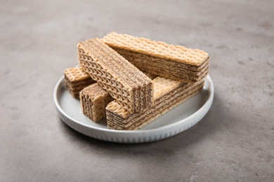 Photo of Plate of delicious wafers on grey stone background