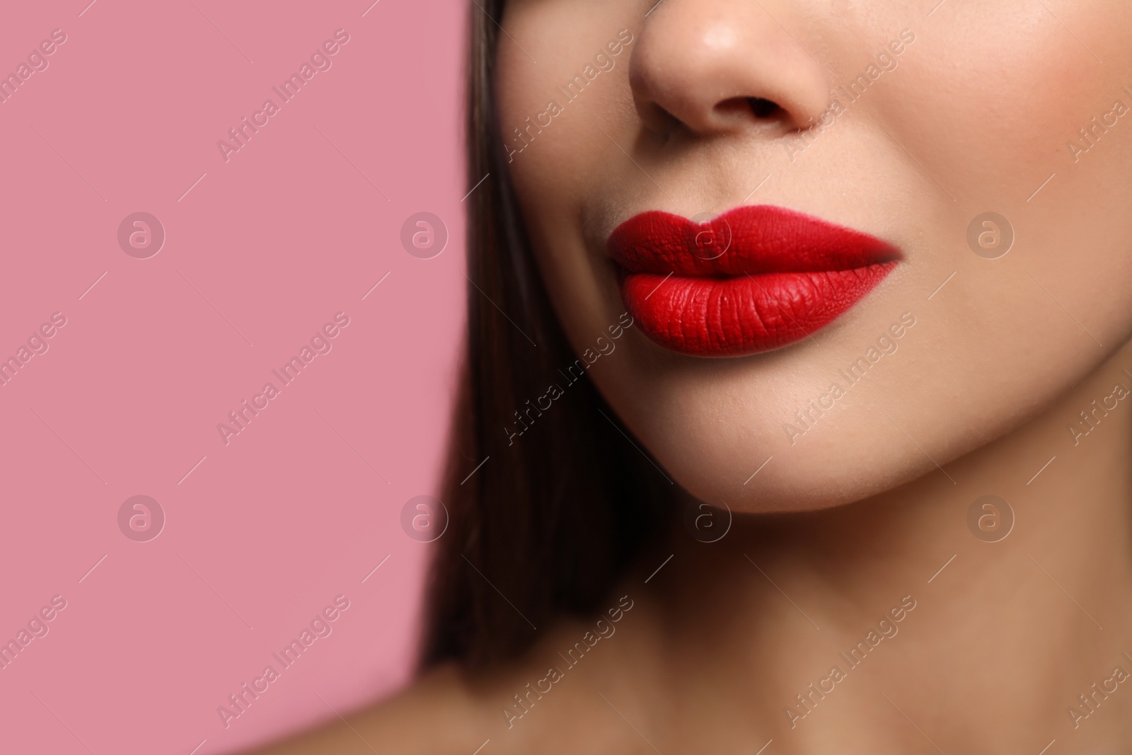 Photo of Woman with red lipstick on pink background, closeup