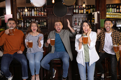 Group of friends watching football in sport bar