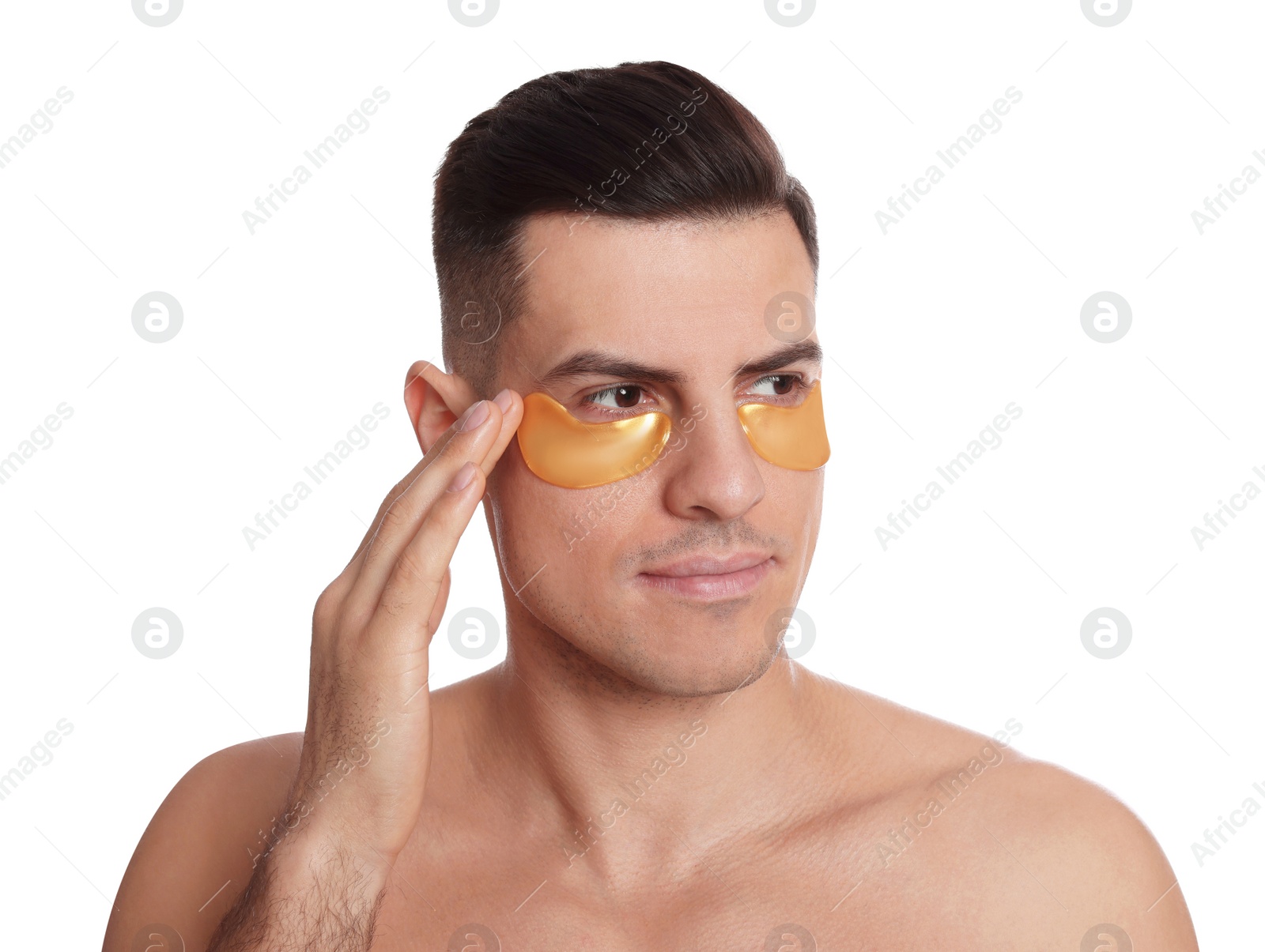 Photo of Man applying golden under eye patch on white background