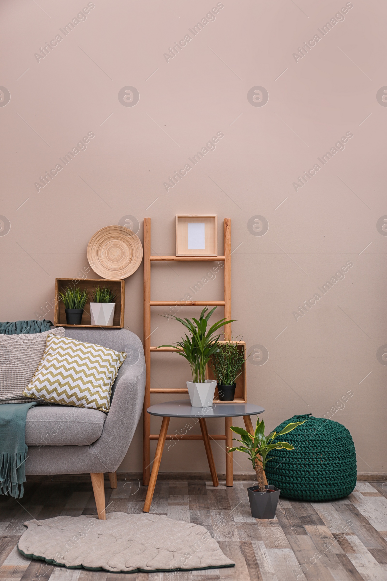 Photo of Modern eco style interior of living room with wooden crates and sofa near color wall