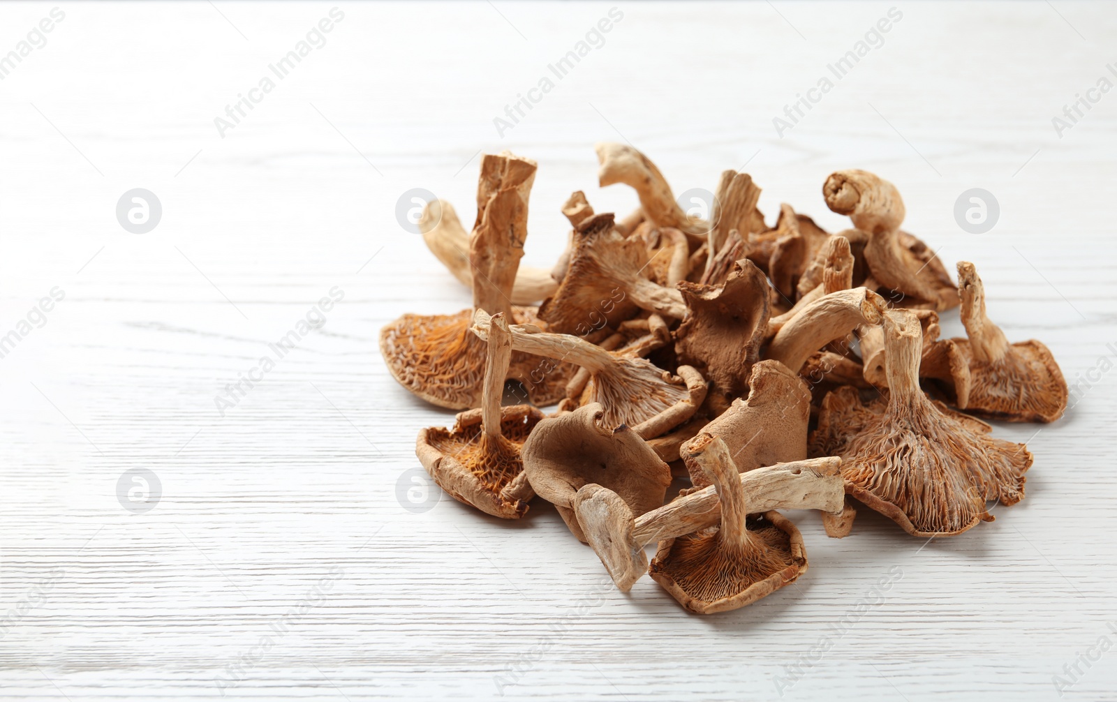 Photo of Dried mushrooms on wooden background. Space for text