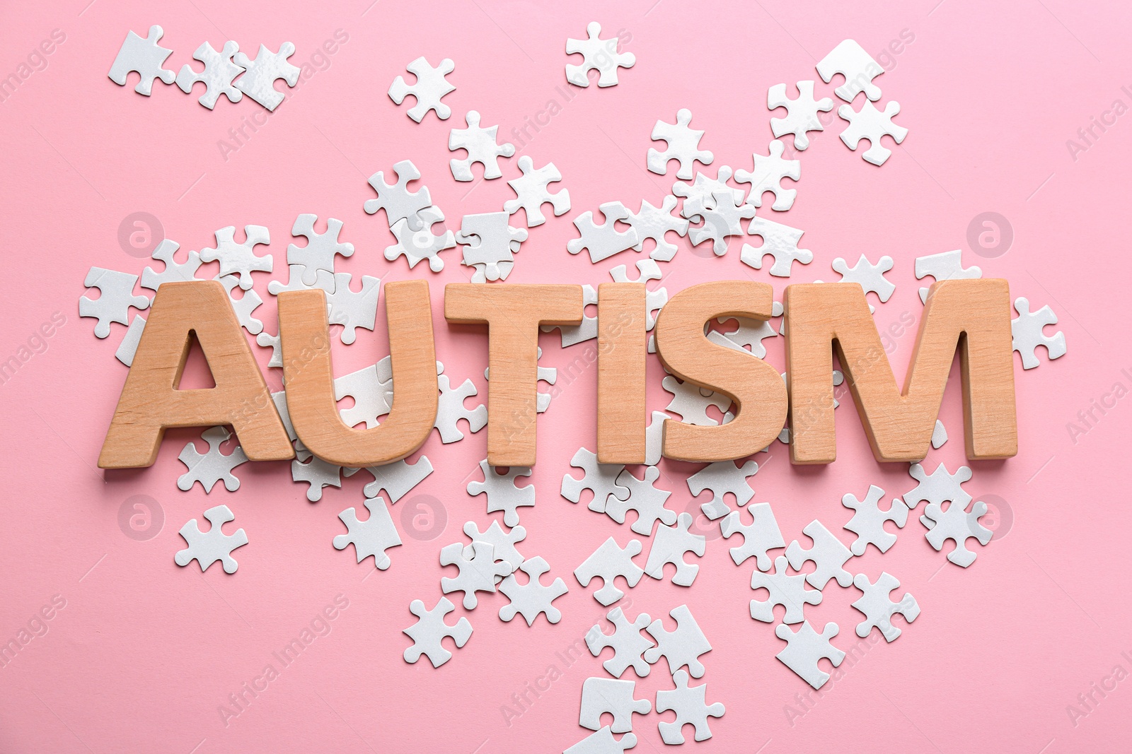 Photo of Word "Autism" and puzzle pieces on color background