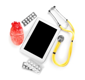 Stethoscope, tablet, pills and model of heart on light background. Heart attack concept
