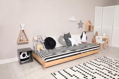 Photo of Cute kids room with stylish comfortable floor bed and toys. Montessori interior