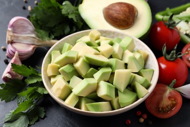 Photo of Fresh ingredients for guacamole on black table, closeup