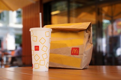 Photo of MYKOLAIV, UKRAINE - AUGUST 11, 2021: Cold McDonald's drink and packed food on table in cafe