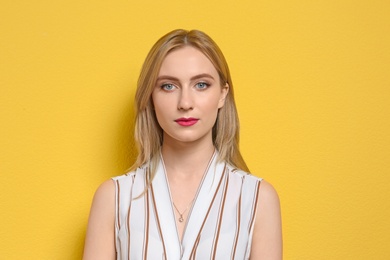 Photo of Attractive young woman in stylish outfit on color background
