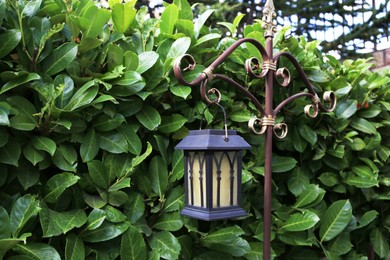 Photo of Beautiful vintage street lamp near green bush outdoors