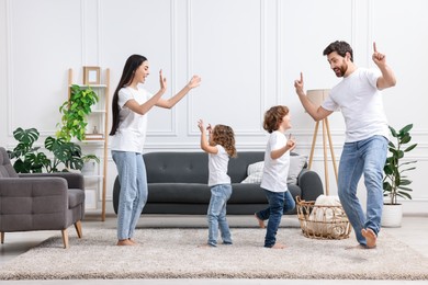 Photo of Happy family dancing and having fun in living room