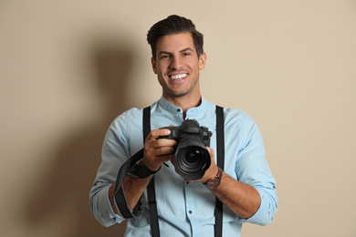 Photo of Professional photographer working on beige background in studio