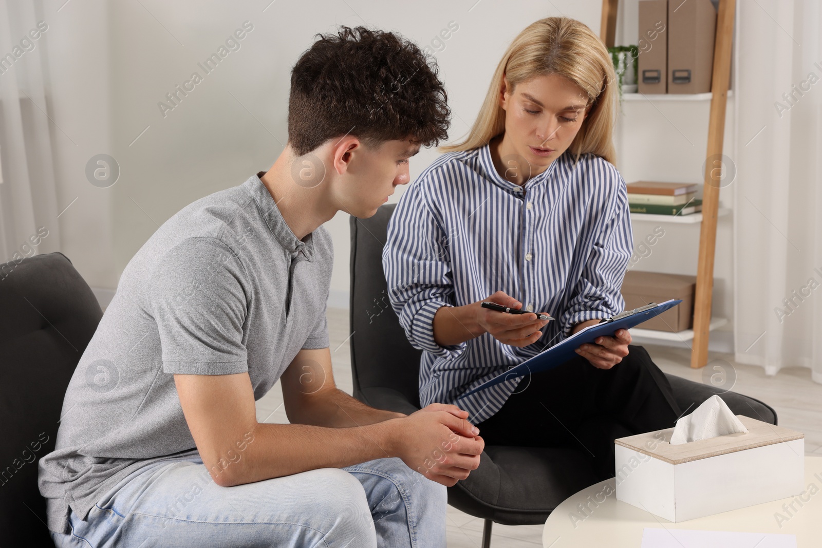 Photo of Psychologist working with teenage boy in office. Teenager problems