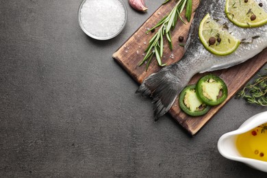 Photo of Fresh dorado fish and ingredients on grey table, flat lay. Space for text