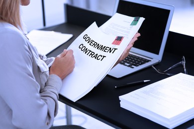 Image of Government contract. Woman reading document at table, closeup