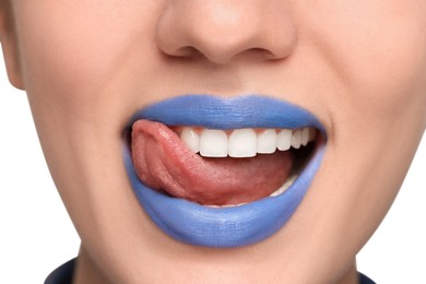 Photo of Woman with blue lipstick showing her tongue on light background, closeup