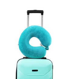 Photo of Soft travel pillow on turquoise suitcase isolated on white