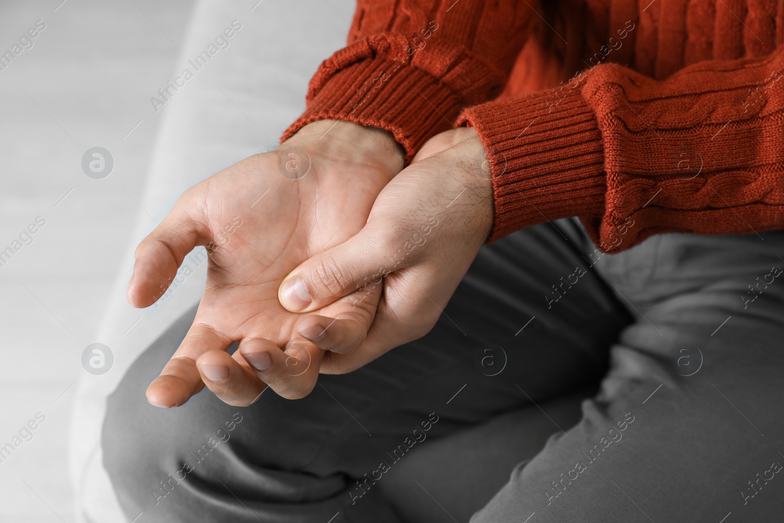 Photo of Man suffering from trigger finger indoors, closeup