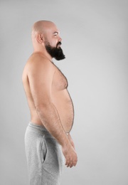 Photo of Fat man on grey background. Weight loss