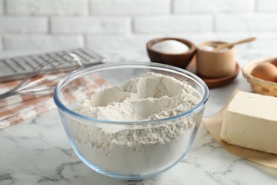 Photo of Making shortcrust pastry. Flour in bowl and butter on white marble table